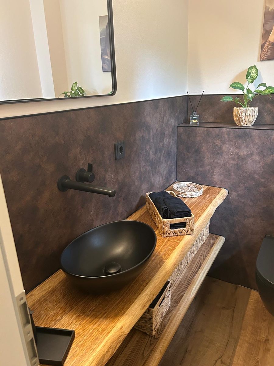 Projekt S. &ndash; G&auml;stebad mit schwarzem Aufsatzbecken, Echtholzregal, Eisenoptik-Fliesen und wandh&auml;ngendem WC