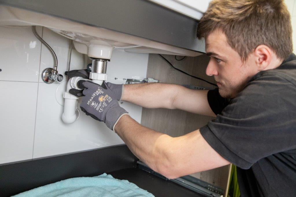 Handwerker verlegt Kupferrohre fachgerecht