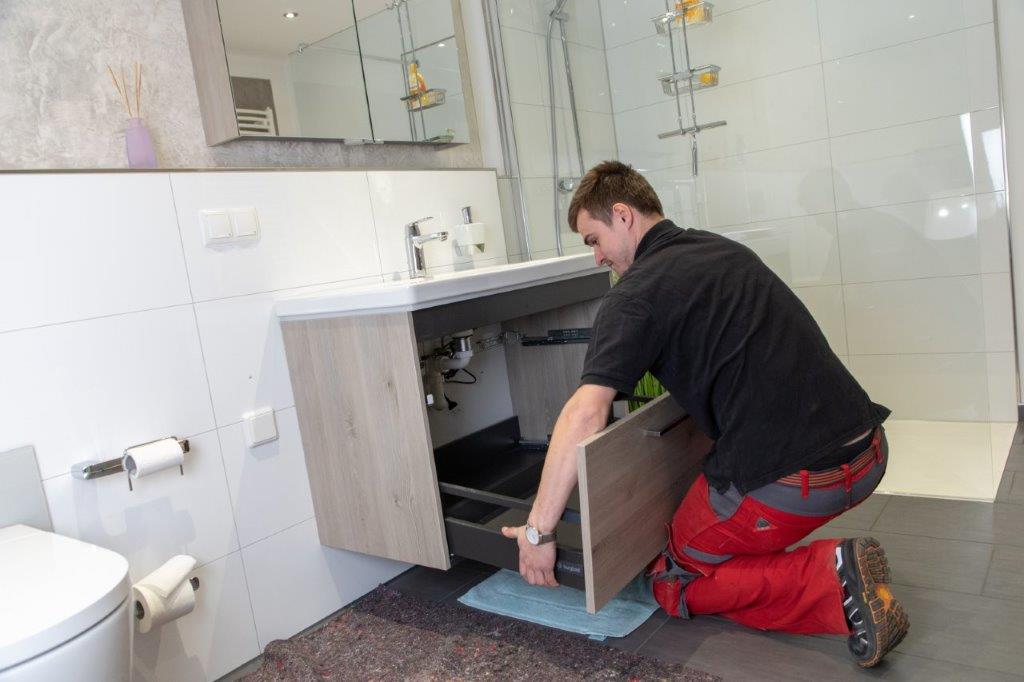SHK-Techniker installiert Armatur im Neubau